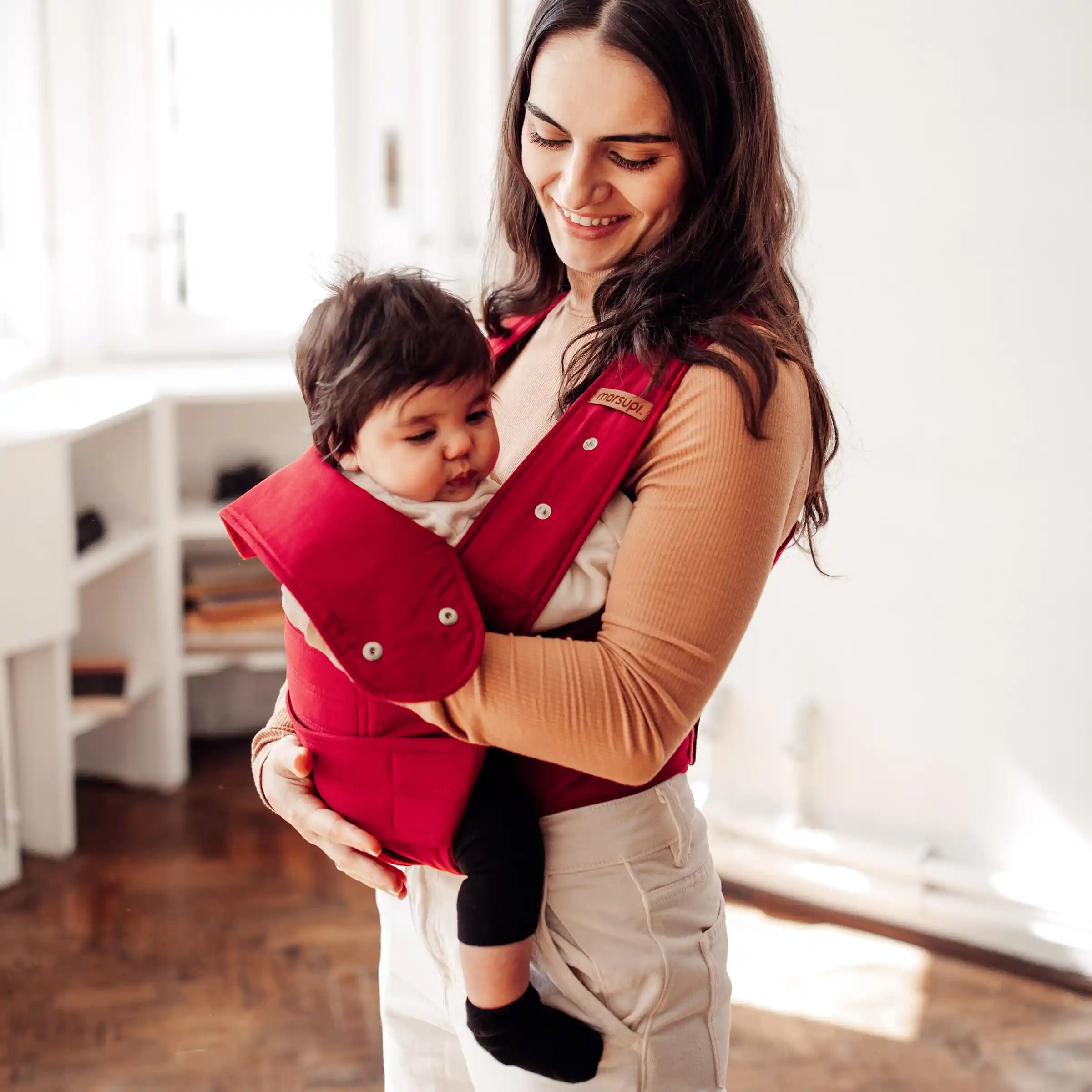 marsupi in rot wird von  utter und baby getragen