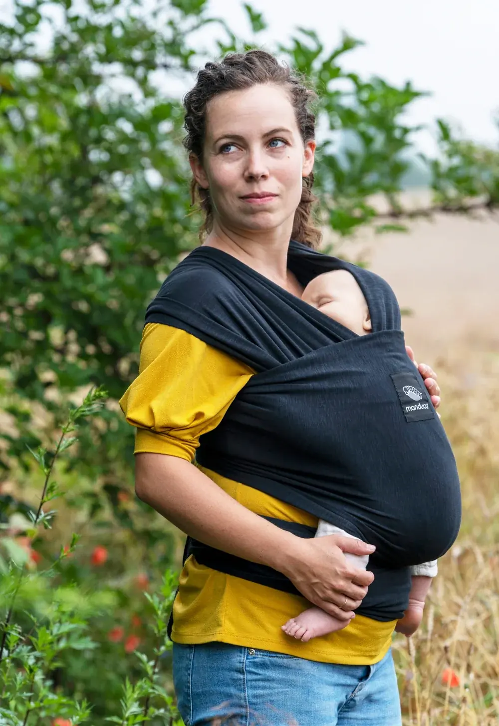 Nahaufnahme: Baby im manduca Sling Baby-Tragetuch Black (Schwarz) – sicherer Halt und Nähe