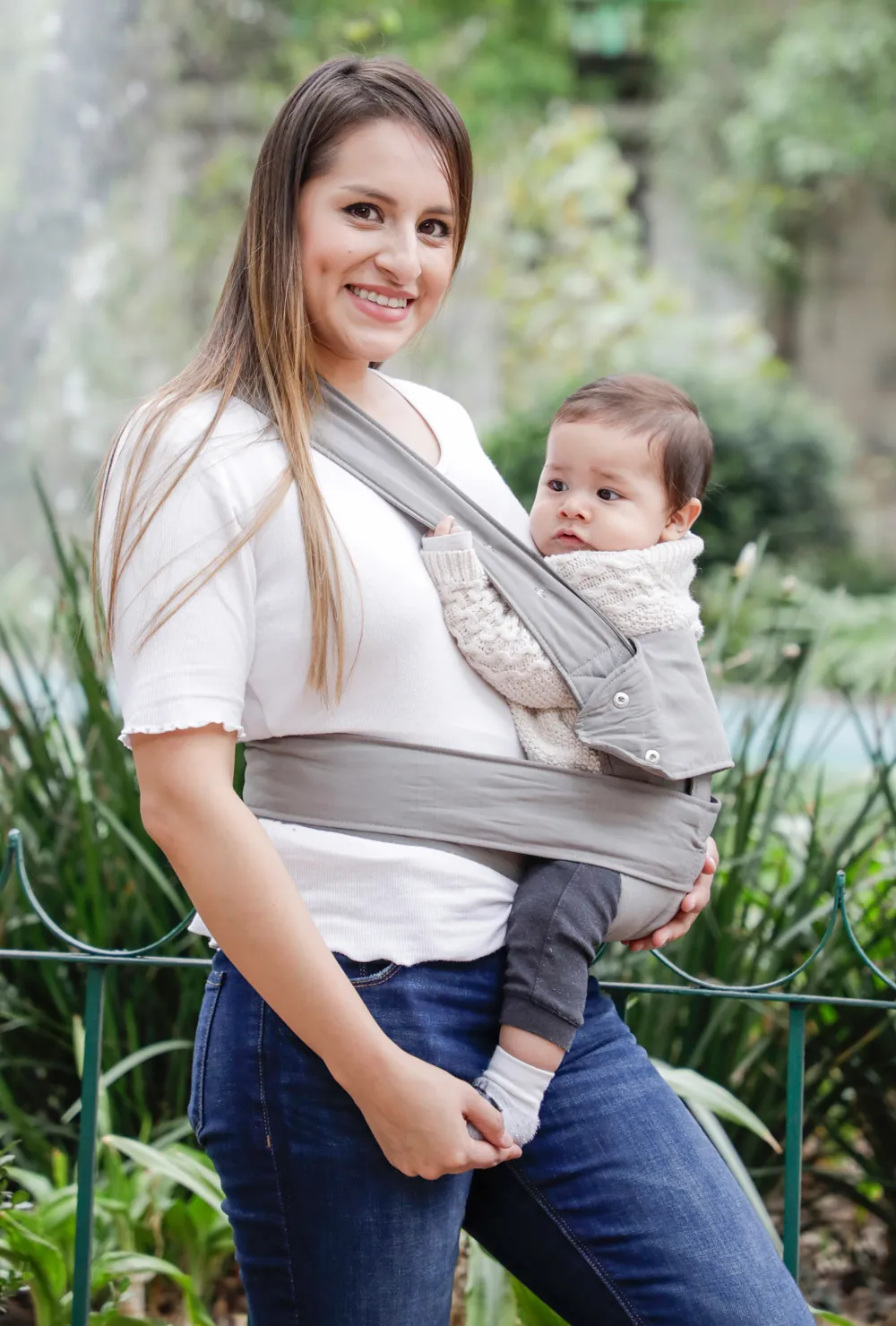 Frau trägt Baby in der marsupi breeze Babytrage in Hellgrau, Outdoor-Aufnahme
