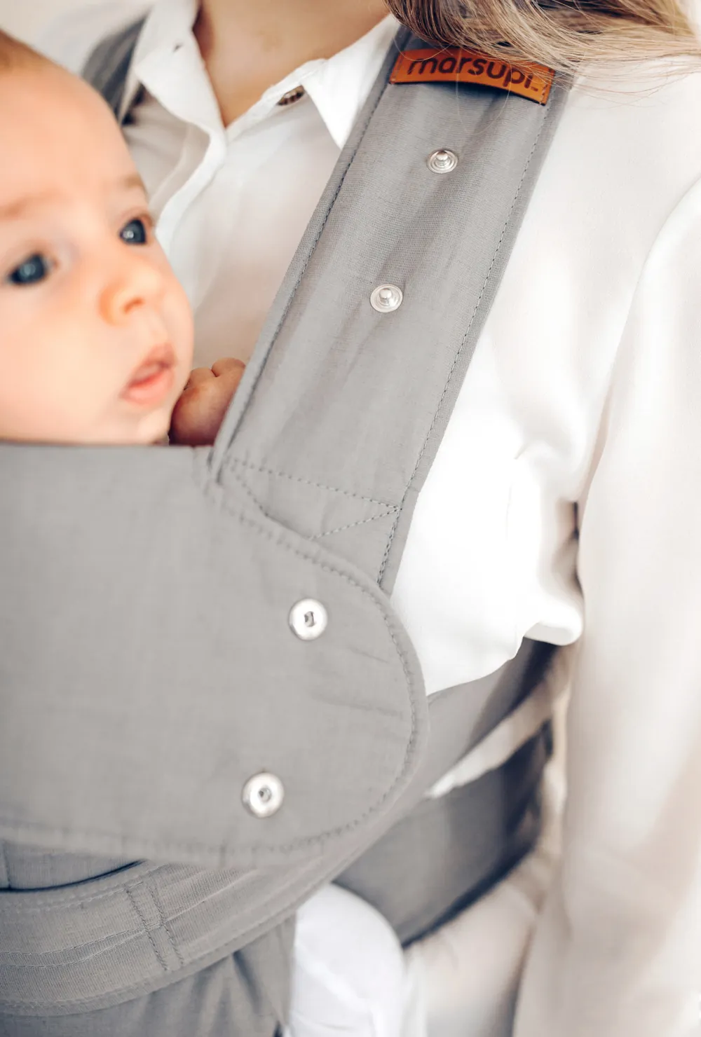 Detailaufnahme der marsupi breeze Babytrage in Hellgrau mit Schulterträger und Druckknöpfen