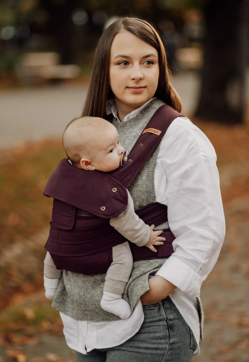 Rückenansicht: gekreuzte Träger der Marsupi Classic 2 Babytrage Berry im herbstlichen Park