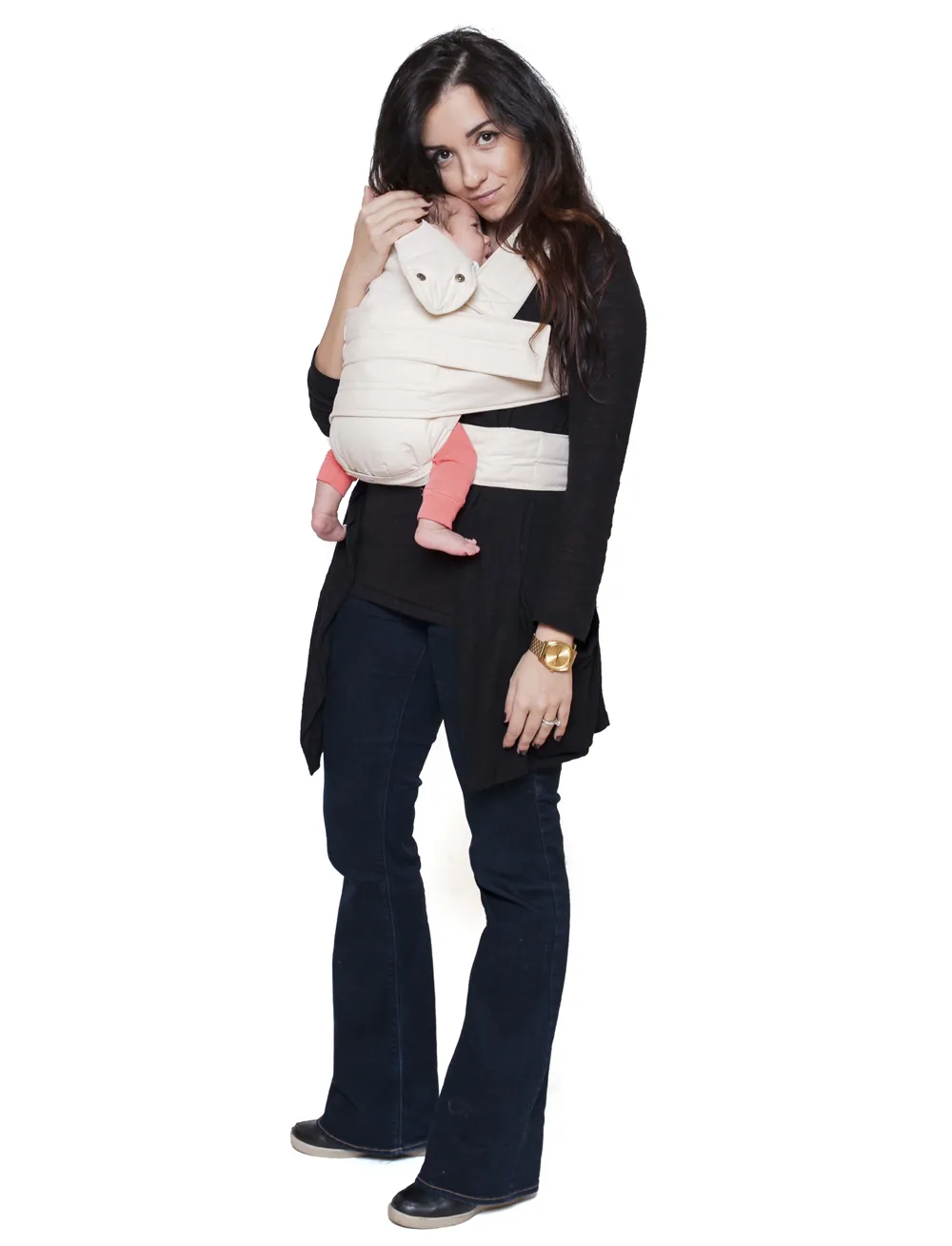 Mutter lehnt am Fenster und trägt Baby in Marsupi Classic 2 Babytrage Natural, Vater sitzt daneben, Kleinkind auf der Fensterbank